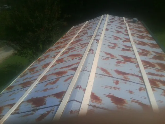 Rusted metal roof panels with new wood purlins before replacement — Storm Damage Roof Repair in Naytahwaush by Roofing Brothers