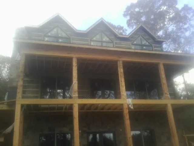 Dormers and porch framing on a large log home under construction — Roof Coating work by our crew in Naytahwaush